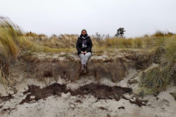 Marina sitzt am Ostseestrand der Insel Poel