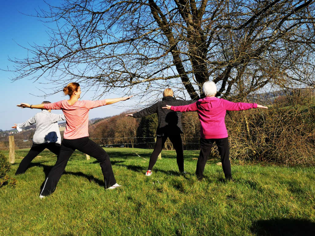 Yoga auf der Wiese vor dem Hotel